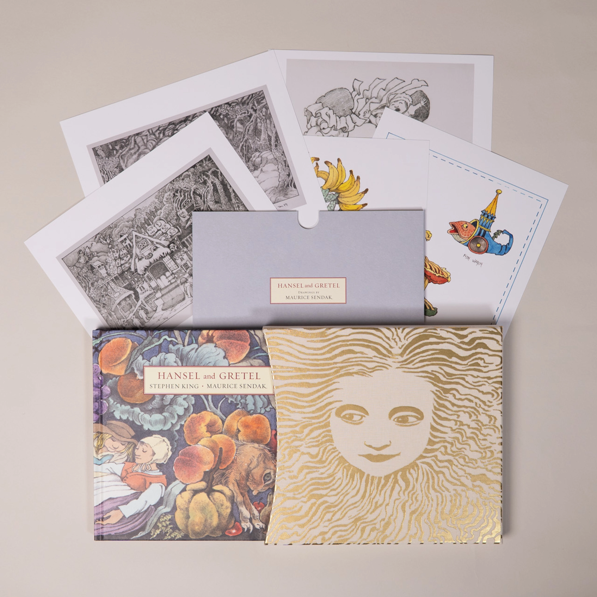 The slipcase, hardback edition, and exclusive prints arranged together